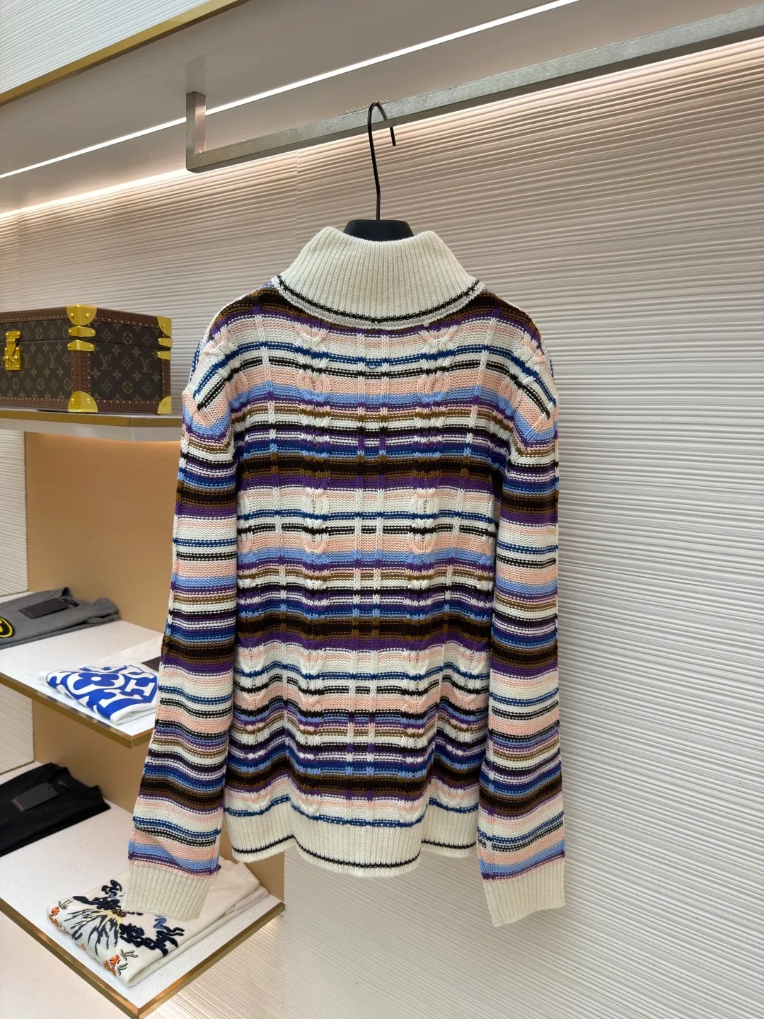 LOUIS VUITTON letter badge color block cable zipper knitted jacket ●Original version: purchased and developed by 21570 ●Item number: 1682322-C15 ●Fabric: wool blended fabric ●Technology: knitting ●Color: pattern ●Version: fitted version ●Weight: about 710 grams ●Size: S-M-L-XL ●Description: This Louis Vuitton color-blocked striped knitted cardigan is made of merino wool and cashmere blended yarn and is woven on a 12-needle coarse-gauge computerized flat knitting machine. The body is interlaced with cable knitting and plain knitting. The stripes are directly knitted with colored yarns instead of post-printing and dyeing. The ratio of colored yarns for each stripe is accurately calculated, making the color transition natural and not easy to fade. The placket is equipped with a customized brass zipper, and the zipper teeth are polished and gold-plated, which is both smooth and durable. The leather label on the left chest is fixed with first-layer calfskin through heat embossing process, and the edges are hand-polished without burrs. The neckline is designed with a high-elastic ribbed stand-up collar, which is not easily deformed after being shaped at high temperatures. The ribbed edges on the cuffs and hem are woven with double-strand yarn, which is more elastic. The shoulders are seamlessly woven with raglan sleeves to reduce the feeling of seams rubbing against the skin. The overall loose fit is combined with three-dimensional tailoring, which not only retains the soft texture of knitting, but also creates a crisp silhouette. Each piece is hand-ironed and quality-checked by brand craftsmen. The overall wiring is straight and delicate, the fabric is comfortable and soft, and the color is consistent without color difference. It can be matched with the same style to create a fashionable look and control various occasions. Customized accessories, complete with three standards, same style for men and women!